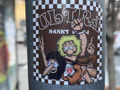 Passeggiando in piazza Umberto ci imbattiamo in altre due stampe. La prima � del St. Pauli, club della serie A tedesca che rappresenta un quartiere di Amburgo famoso per essere �a luci rosse�, nonch� un luogo di ritrovo dei punk di tutto il mondo
